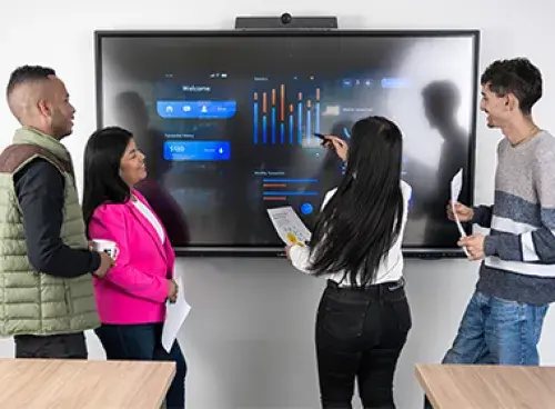 Varias personas en una reunión, con un televisor al fondo.